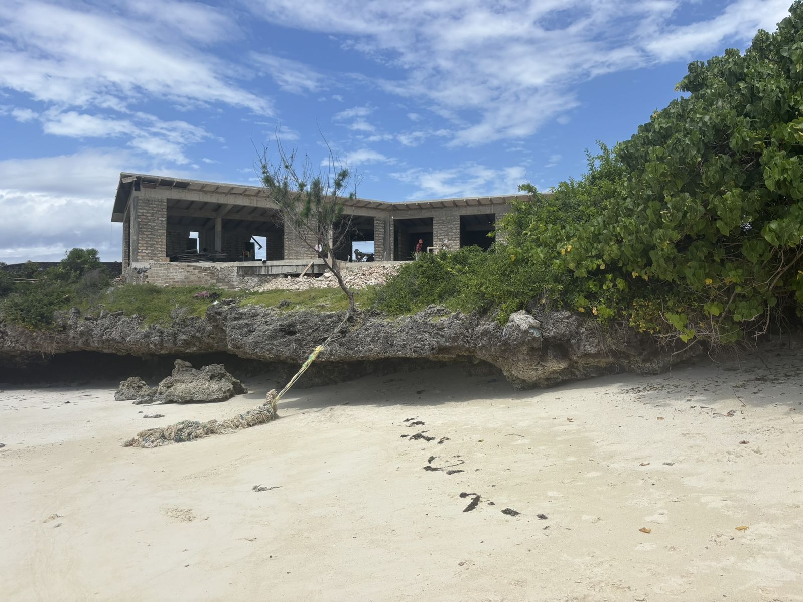 The walls of the villa standing at the edge of the cliff, seen from the beach